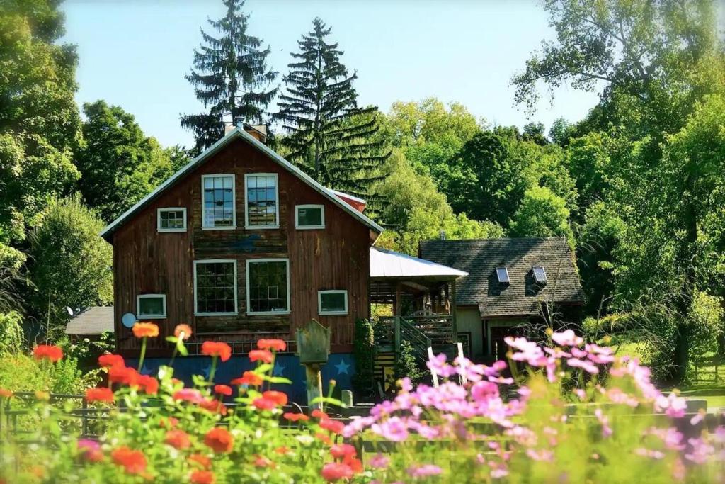 a wooden house with flowers in front of it at The Spirit Horse Farm, Kent Connecticut in Kent
