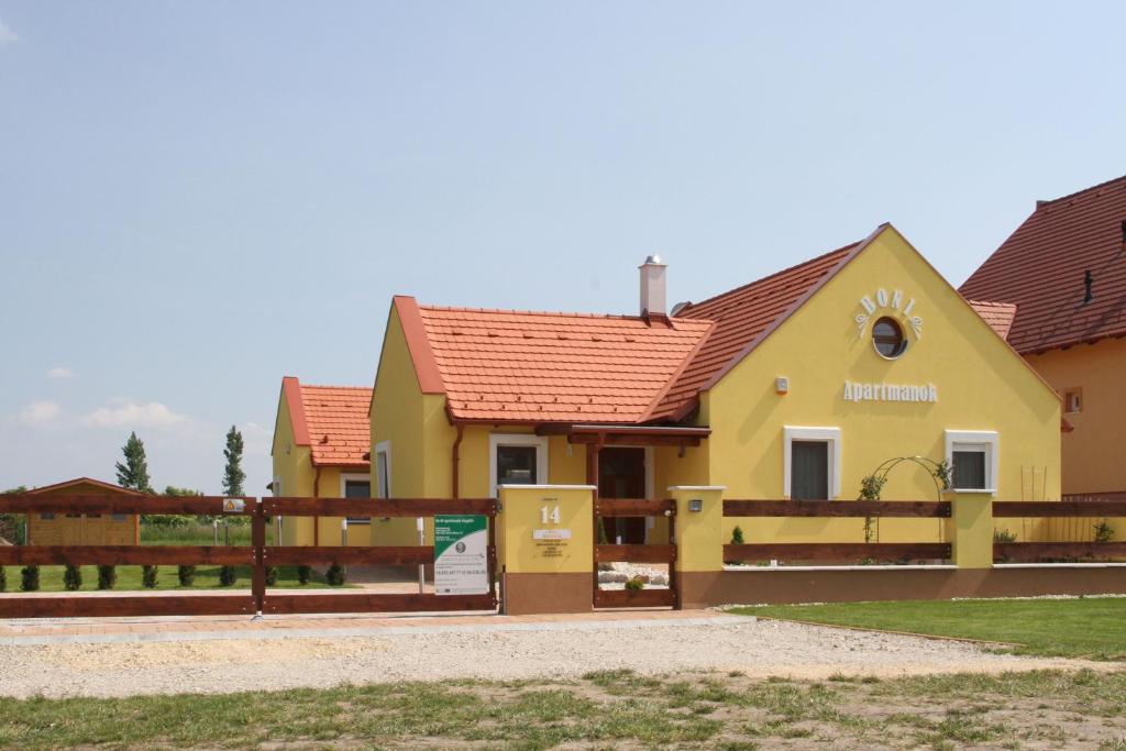 una casa amarilla con techo rojo en BONI APARTMAN Hegykő en Hegykő