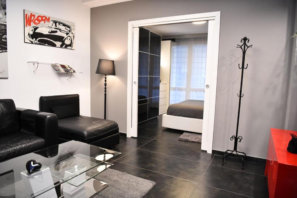 a living room with a black couch and a bedroom at La casa di Gabry Prestige in Albano Laziale