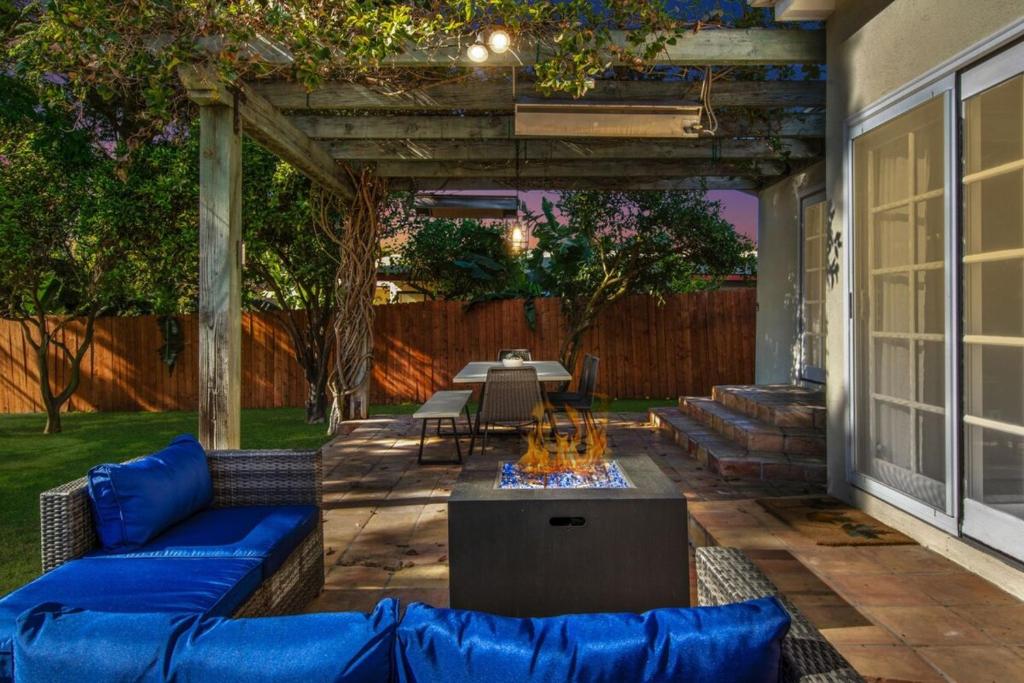 レドンドビーチにあるBeach Breeze Bungalow 1 Miles To Beach Cozyの青いソファとテーブル付きの裏庭のパティオ