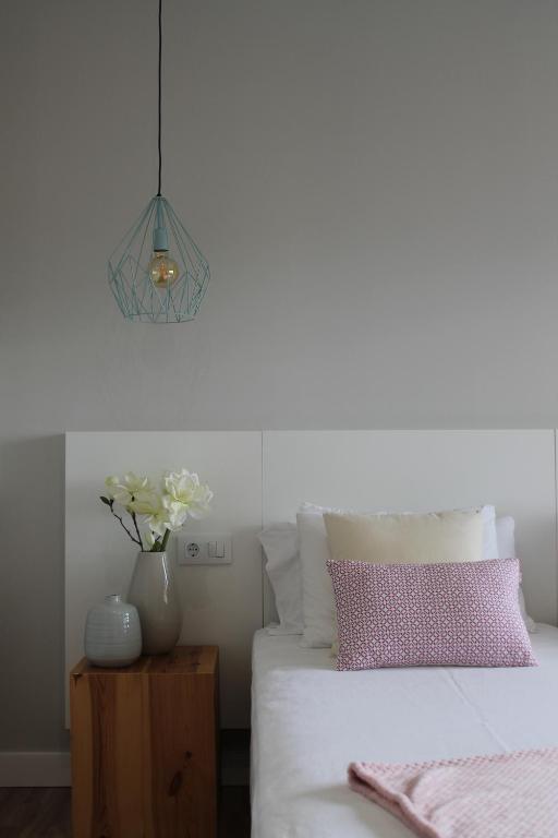 a bedroom with a bed and a vase of flowers on a table at Habitación Privada - Baiona in Baiona