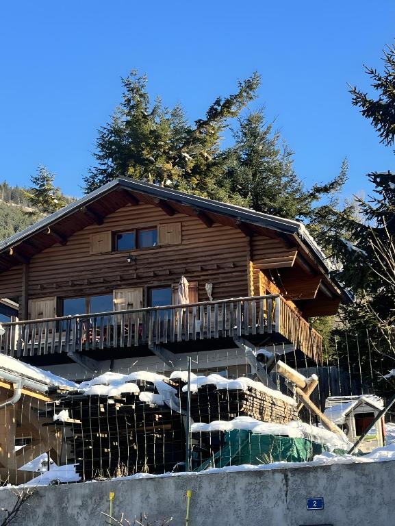 une cabane en rondins dans la neige avec un balcon dans l'établissement Au Soleil, à Séez