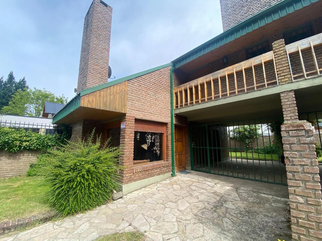 a large brick building with a gate in front of it at Cabaña hasta para 6 personas en San Martin de los Andes in San Martín de los Andes