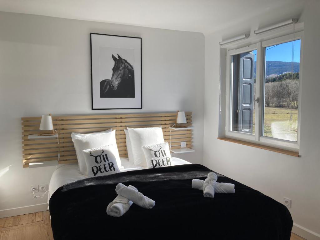 a bedroom with a bed with two stuffed animals on it at Authentique ferme Cerdane entièrement rénovée in Caldégas