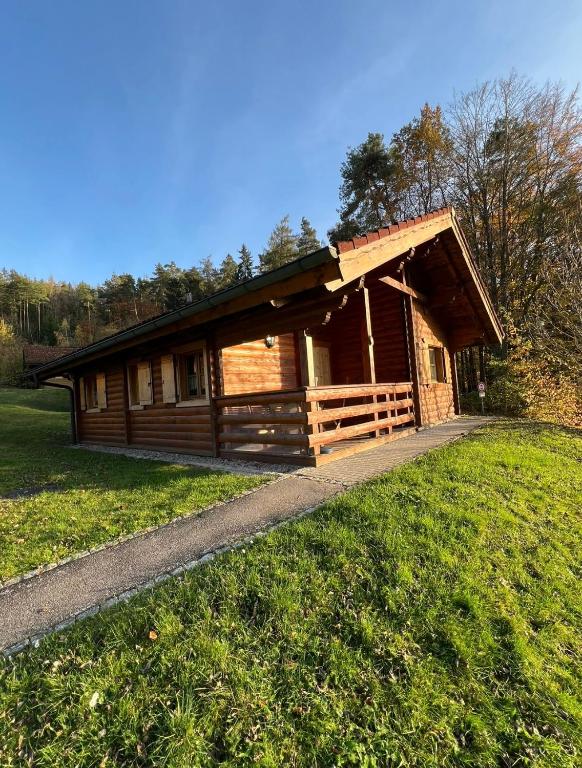 a log cabin in a field with a grass field at Blockhaus Holzzeit im Bayerischen Wald in Stamsried