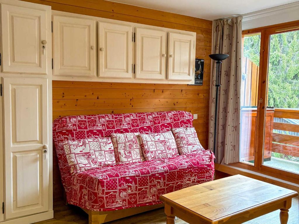 un salon avec un canapé rouge et une table dans l'établissement Appartement à Notre-Dame-de-Bellecombe, 2 chambres, 6 pers, cuisine équipée - FR-1-807-59, à Notre-Dame-de-Bellecombe