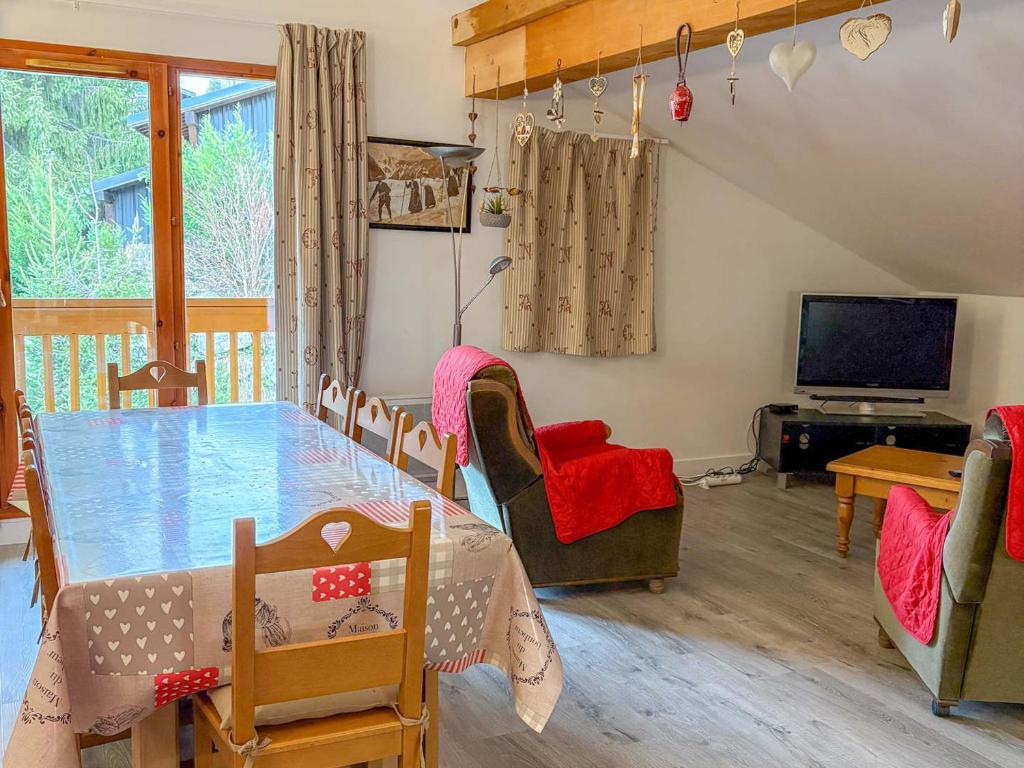 圣母贝莱克Bel appartement cosy 3 chambres à Notre-Dame-de-Bellecombe - FR-1-807-67的一间带桌椅和电视的餐厅