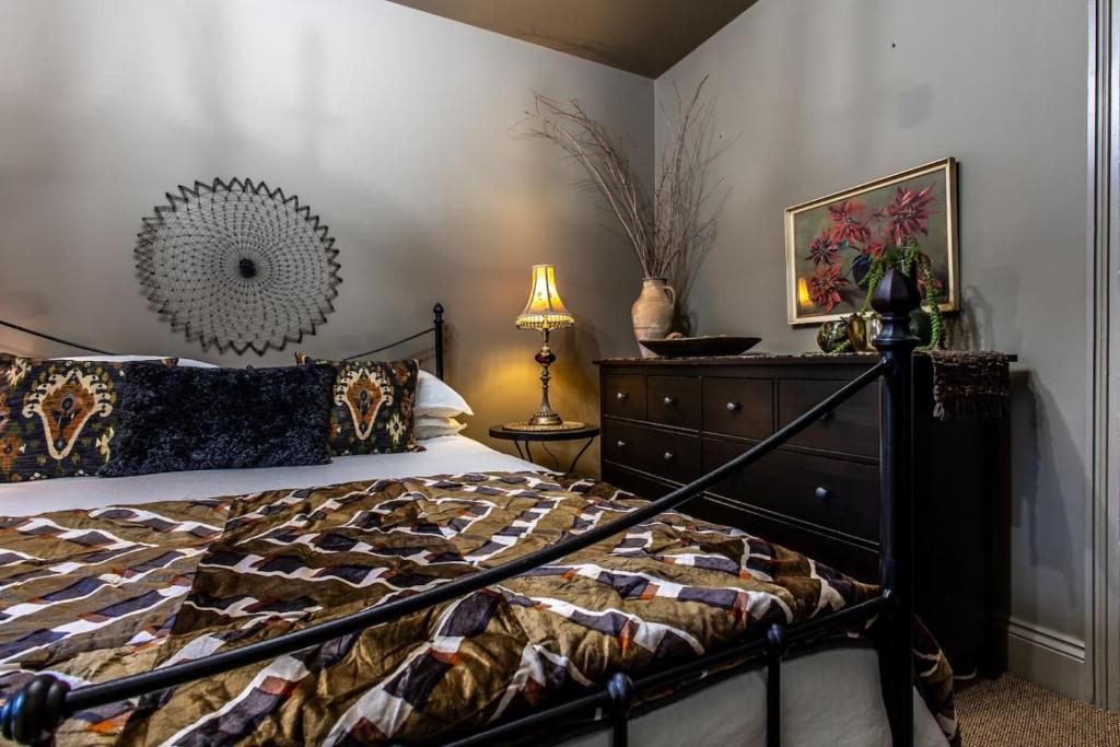 a bedroom with a bed and a dresser at Stay In Style At Olive 77 Book Your Trip Now in Hanwell