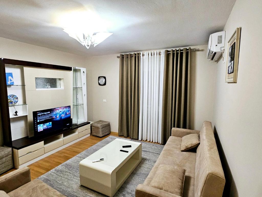 a living room with a couch and a tv at Tirana Center - AAL in Tirana
