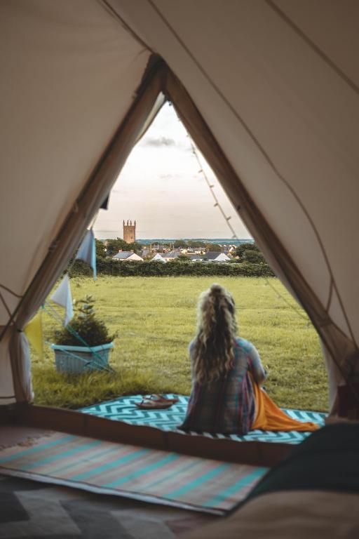 a man sitting in a tent looking out the window at Trevena Cross Glamping & Camping in Helston