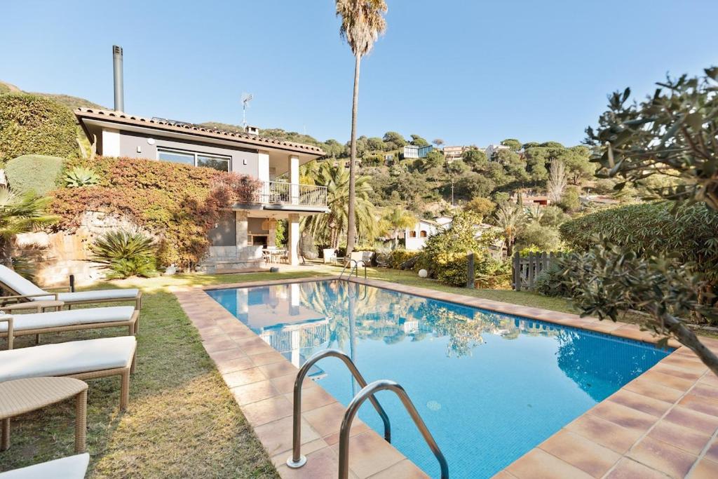 a swimming pool in front of a house at Chez Pablo Barcelona in Cabrils
