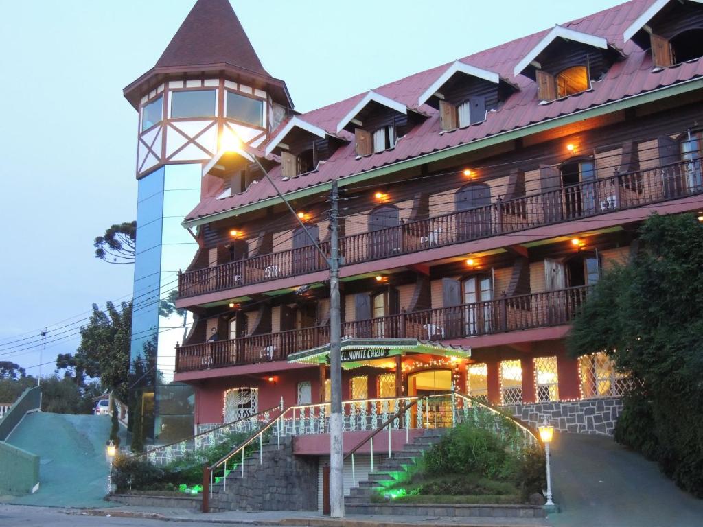 un gran edificio con una torre de reloj delante de él en Hotel Monte Carlo, en Campos do Jordão