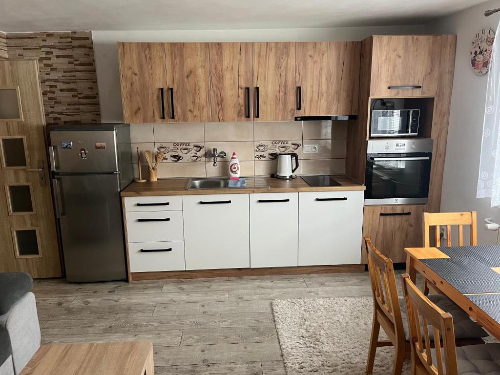 una cucina con armadi bianchi e un tavolo con tavolo. di A&A Apartmany a Liptovský Mikuláš