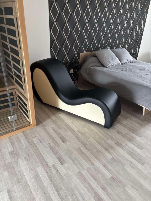 - une chambre avec un lit et une chaise noire dans l'établissement Nuit détente, à Saint-Christophe-en-Brionnais