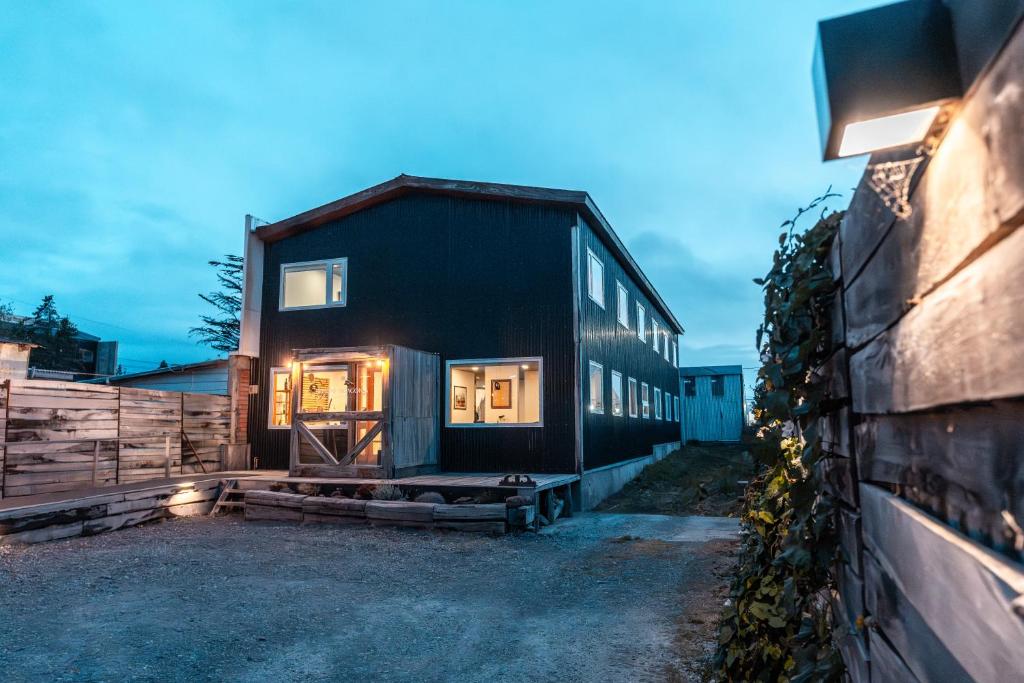 a black house with the door open in a yard at Pristine Patagonia Hotel in Puerto Natales