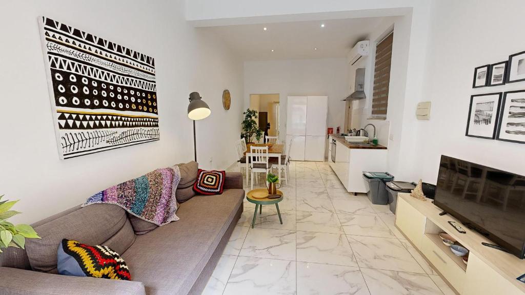 a living room with a couch and a kitchen at Seaside Apartment Steps Away From The Sea in Il-Gżira