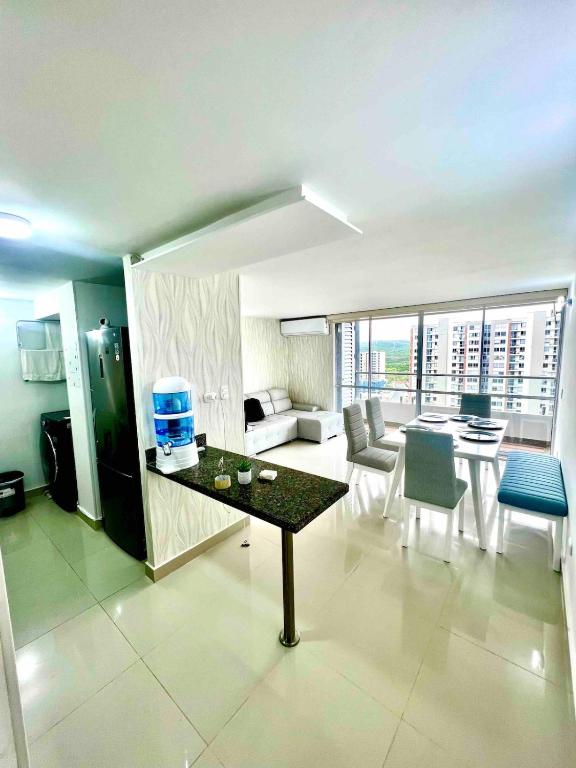 un salon avec une table et un canapé dans l'établissement Nuevo apartamento de lujo con balcón wifi AC piscina, à Barranquilla