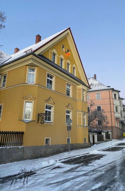 a yellow house with a star on the roof at Wohnen in der alten Max Selbmann Villa in Hohenstein-Ernstthal