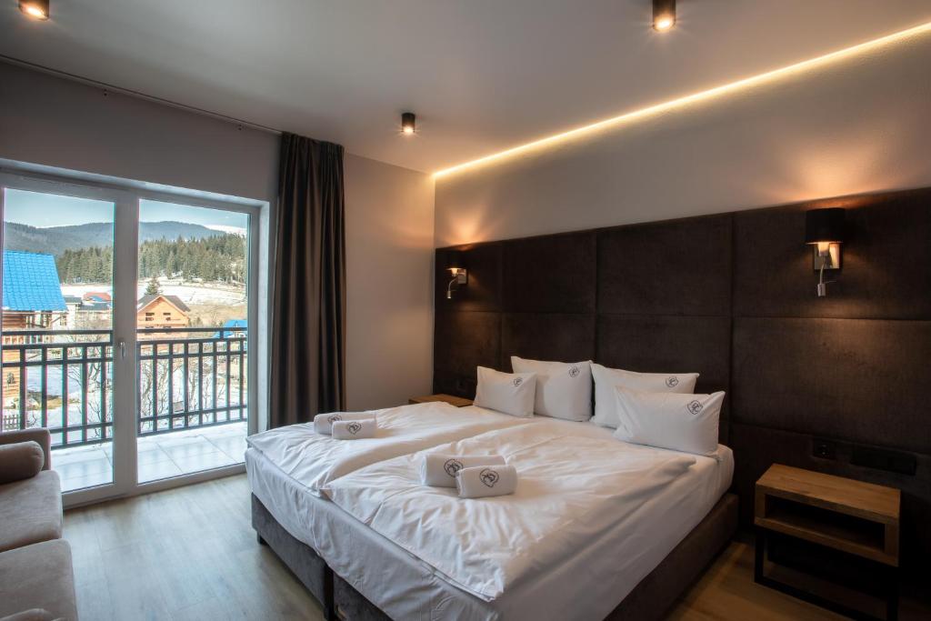 a bedroom with a large bed with a large window at Premium Club SPA in Bukovel