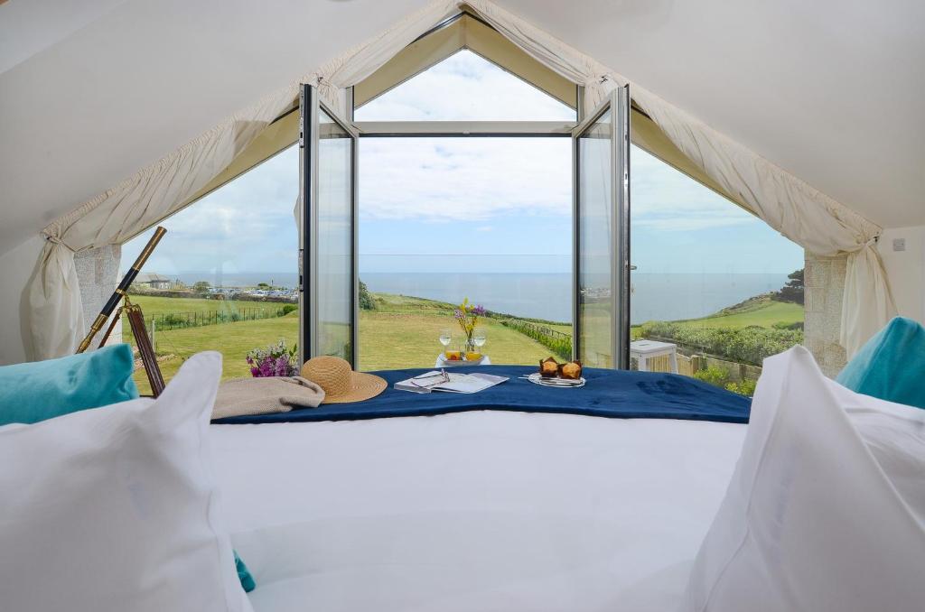 ペンザンスにあるSEA BREEZE - Stunning 6 Bedroom Eco Home with Sea Viewsの海が見えるテーブル付きのテント