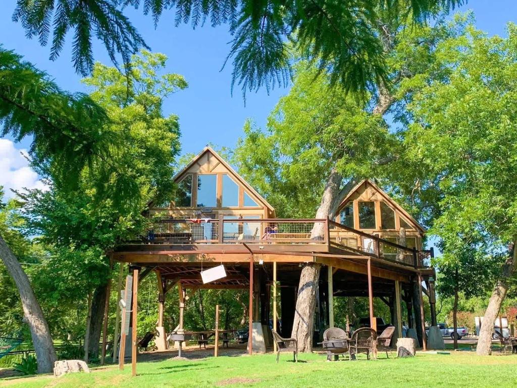 a tree house with a wrap around porch at Waterfront Prairie Flower Treehouse in Seguin
