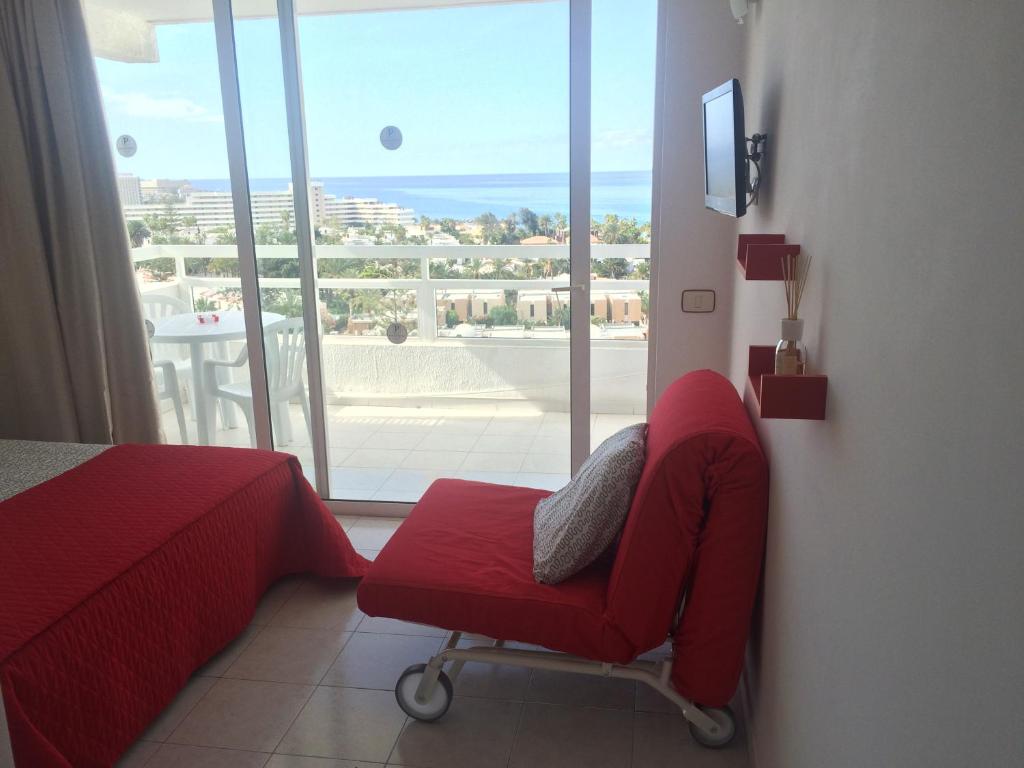 美洲海灘的住宿－Apartment Venezuela，窗户房间里一张红色的椅子