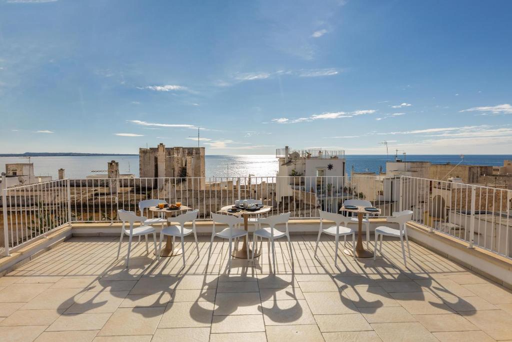 Dimora Suite Oro في غالّيبولي: فناء به طاولات وكراسي على شرفة