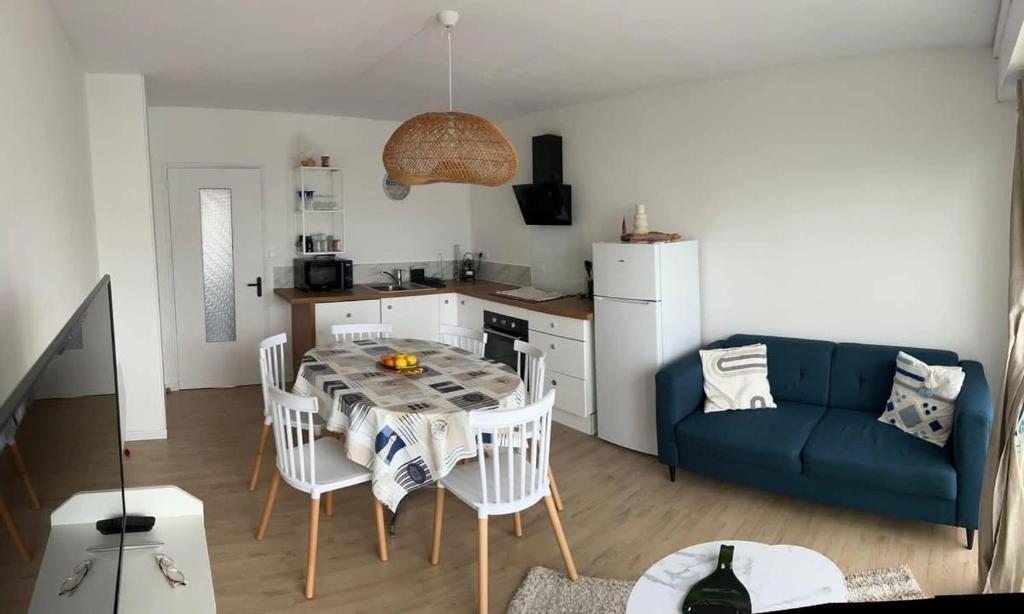 un salon avec une table et un canapé bleu dans l'établissement La roue Bleue, à Saint-Jean-de-Monts