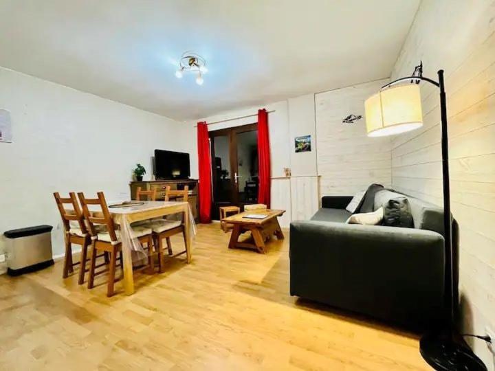 un salon avec un canapé et une table dans l'établissement Appartement Allemond 6 personnes, à Allemont