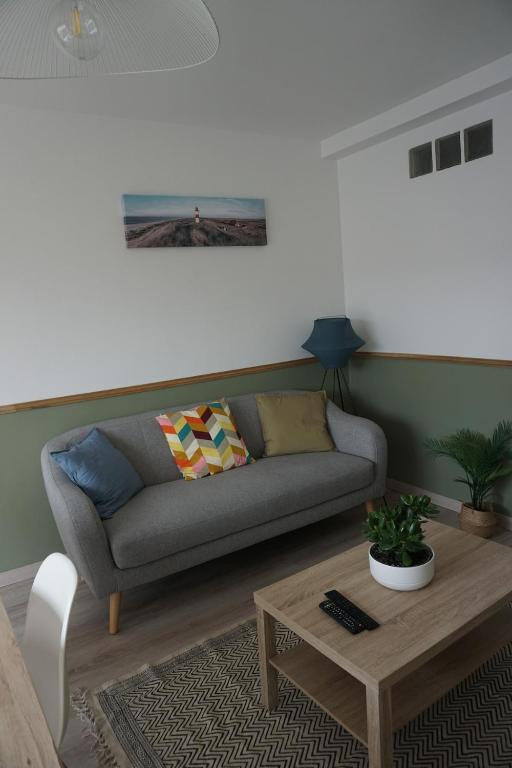 un salon avec un canapé et une table basse dans l'établissement Appartement confortable, à Caen