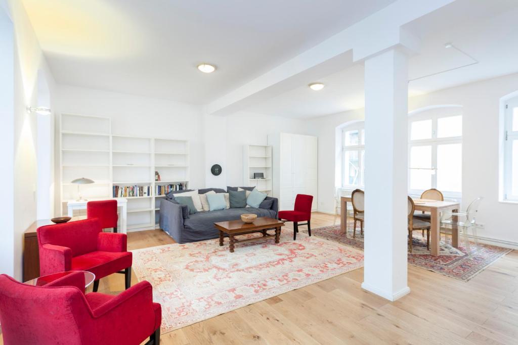 ein Wohnzimmer mit roten Stühlen und einem blauen Sofa in der Unterkunft GreatStay Apartment - Torstraße in Berlin