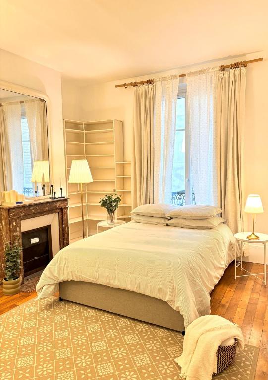 - une chambre avec un grand lit et une cheminée dans l'établissement 4 Guests Apt Jardin des Plantes, à Paris