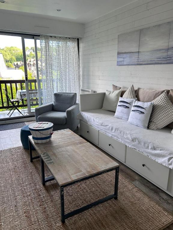 un salon avec un canapé et une table dans l'établissement Deauville - appartement avec terrasse face à l'Hippodrome, à Deauville