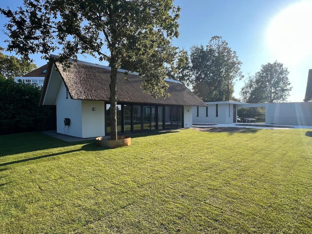 un edificio bianco con un albero nel cortile di Guesthouse 'Elements' with panoramic views a Bergen