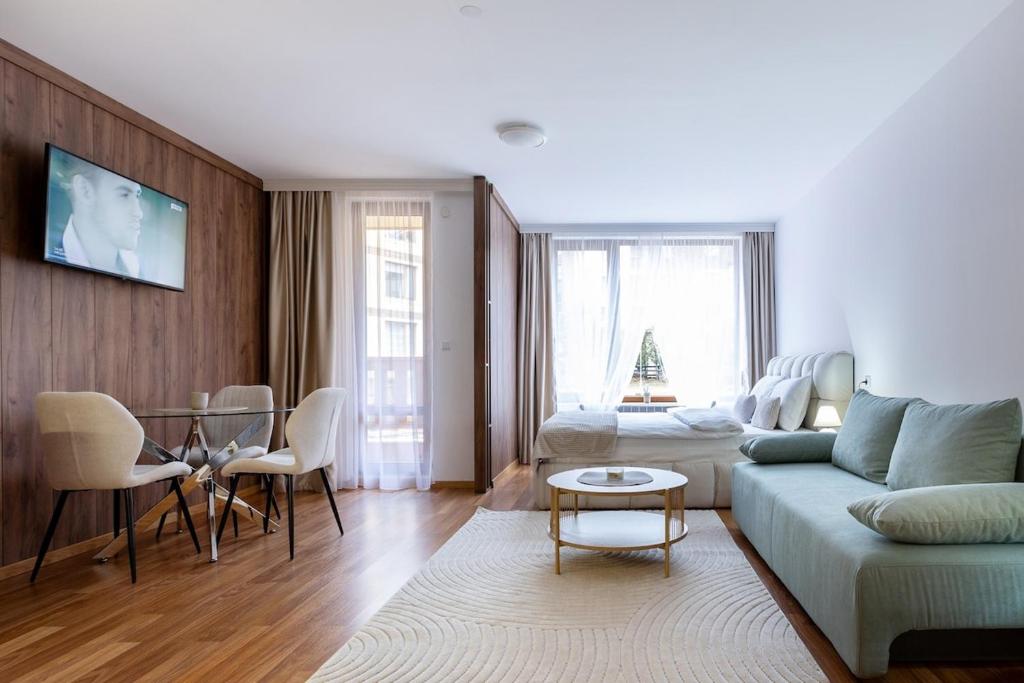 een woonkamer met een bank en een tafel bij Pirin Sense Mountain Paradise Escape - SPA - Free Parking in Bansko