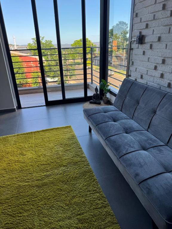 a living room with a couch and a large window at Apartamento Loftier Brete in Posadas