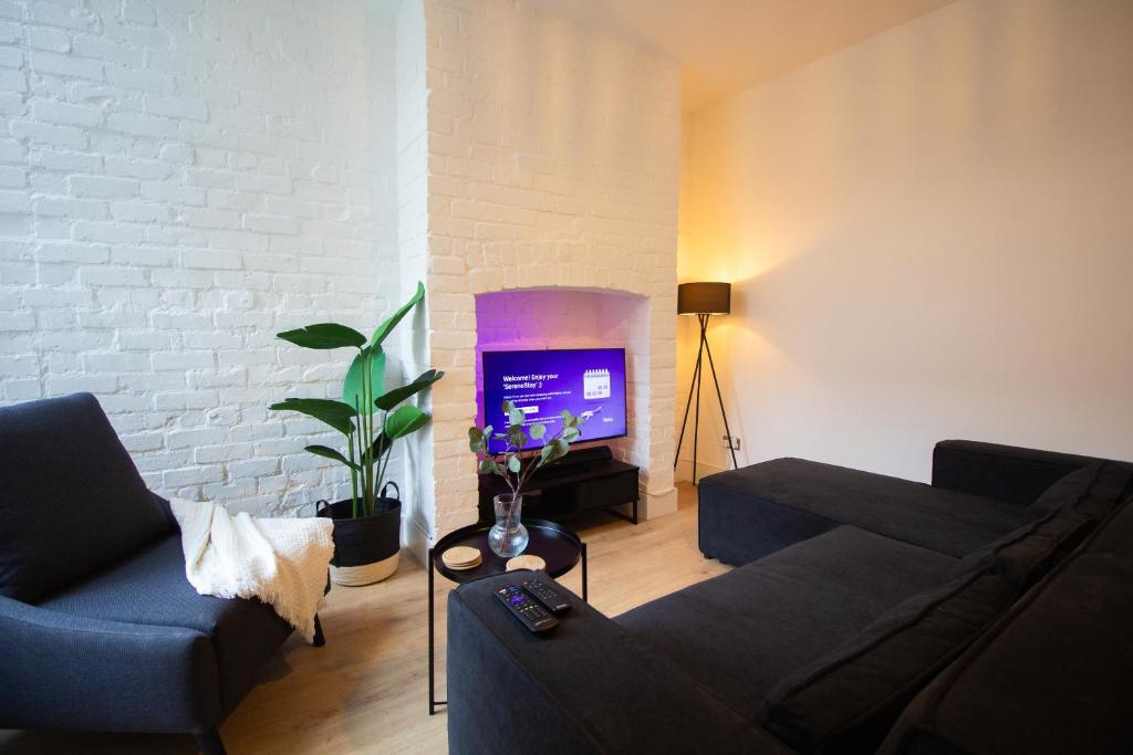 a living room with a couch and a tv at Stylish Cosy 4-Bed Home, Sleeps Up To 10 With Large Sofa Bed, Near Manchester Royal Infirmary & Universities, Free Parking & Ultra-Fast WiFi in Manchester