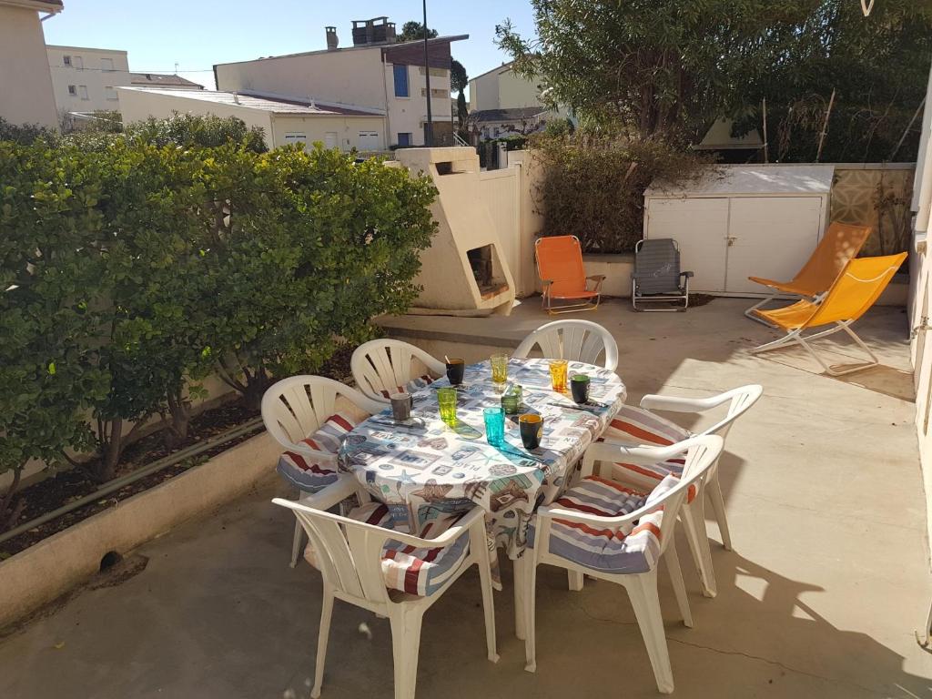 une table et des chaises assises sur une terrasse dans l'établissement Narbonne-Plage : Appartement T2 Climatisé, 35m², Pieds dans l'eau, 4 Pers. - FR-1-795-50, à Narbonne