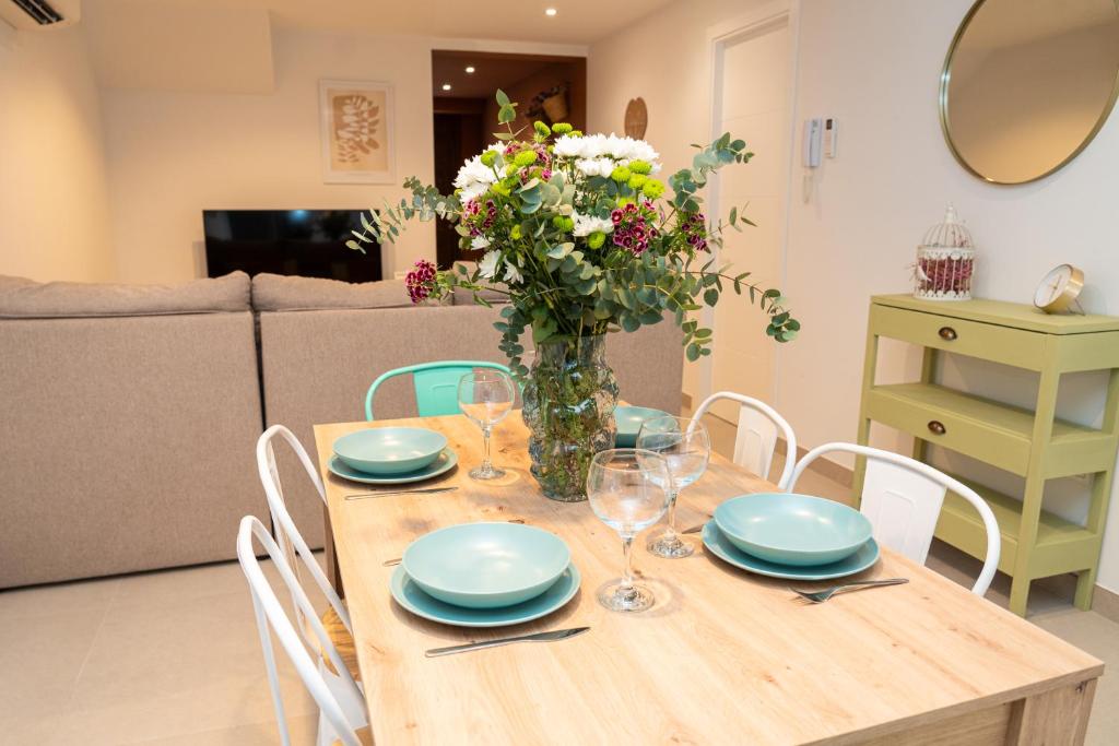 a dining room table with a vase of flowers on it at Apartamento Molino y GARAJE in Ronda