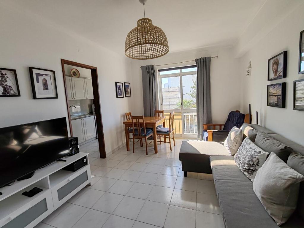 a living room with a couch and a television at 4C Atlantico 1 - Casas & Papeis in Armação de Pêra