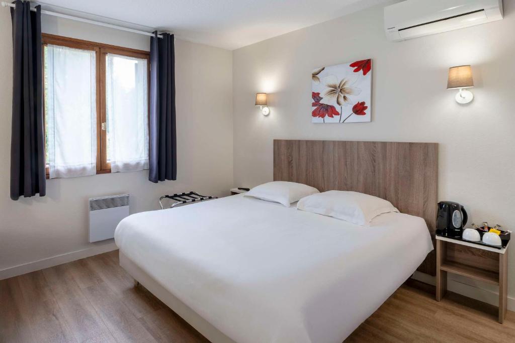 a bedroom with a large white bed and a window at Sure Hotel by Best Western Saintes in Saintes