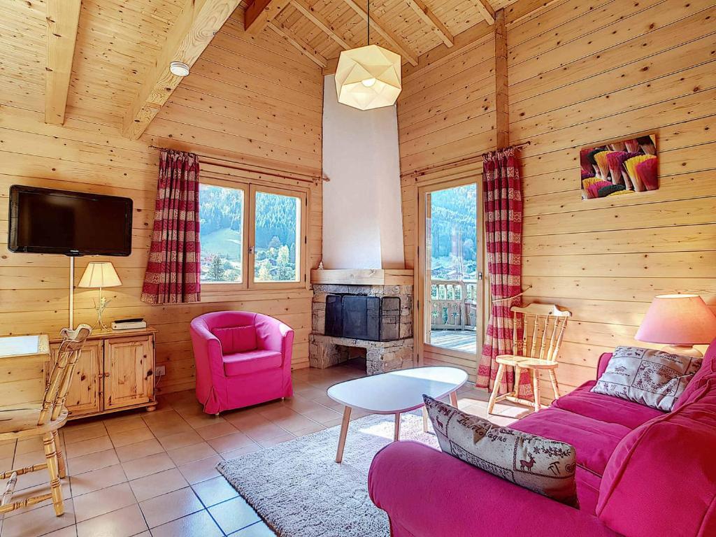 - un salon avec un canapé et une télévision dans une cabine dans l'établissement Chalet confortable 6 pers avec cheminée, WIFI, animaux admis, parking - La Clusaz - FR-1-818-71, à La Clusaz