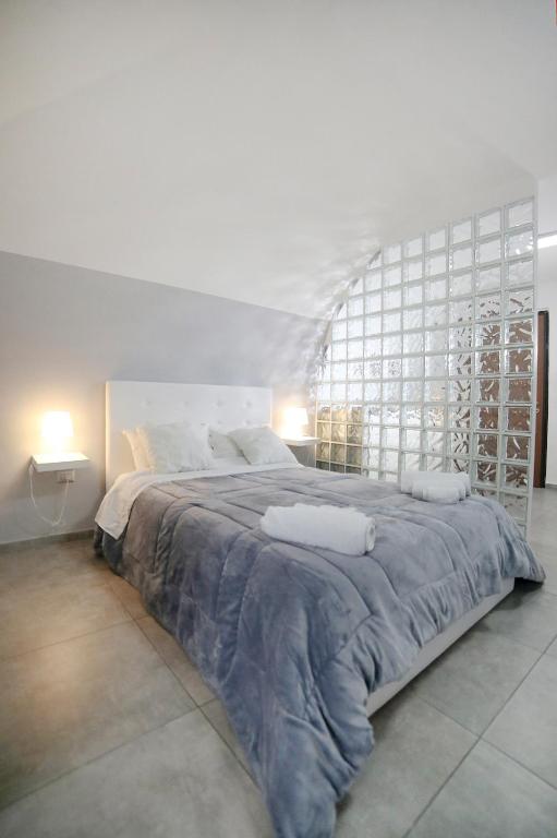a white bedroom with a large bed with a large window at Casa Sant Anna in Naples