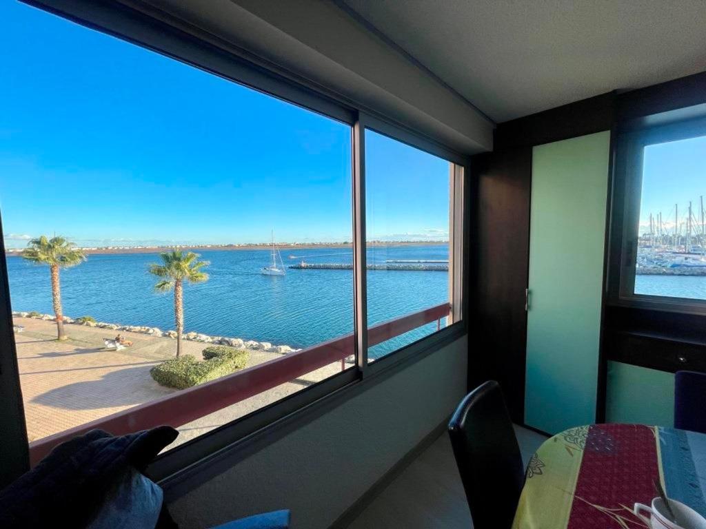 Cette chambre dispose d'une grande fenêtre offrant une vue sur l'eau. dans l'établissement T2 Spacieux, Proche Plage, Parking Privé - FR-1-796-82, à Gruissan