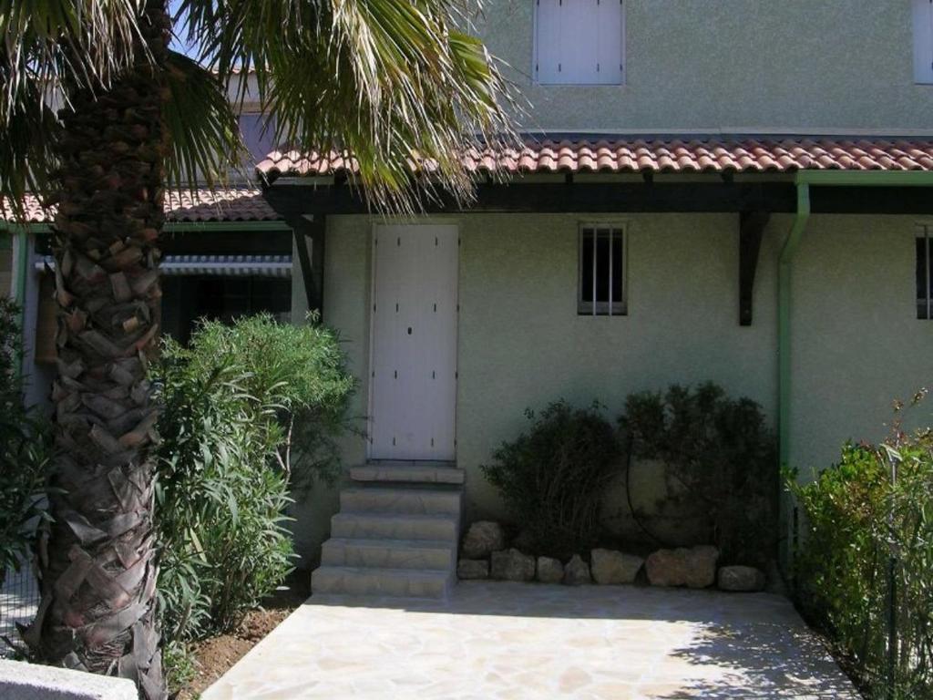 une maison avec un palmier devant dans l'établissement Pavillon climatisé avec piscine, proche plage, 2 chambres - FR-1-781-81, à Valras-Plage
