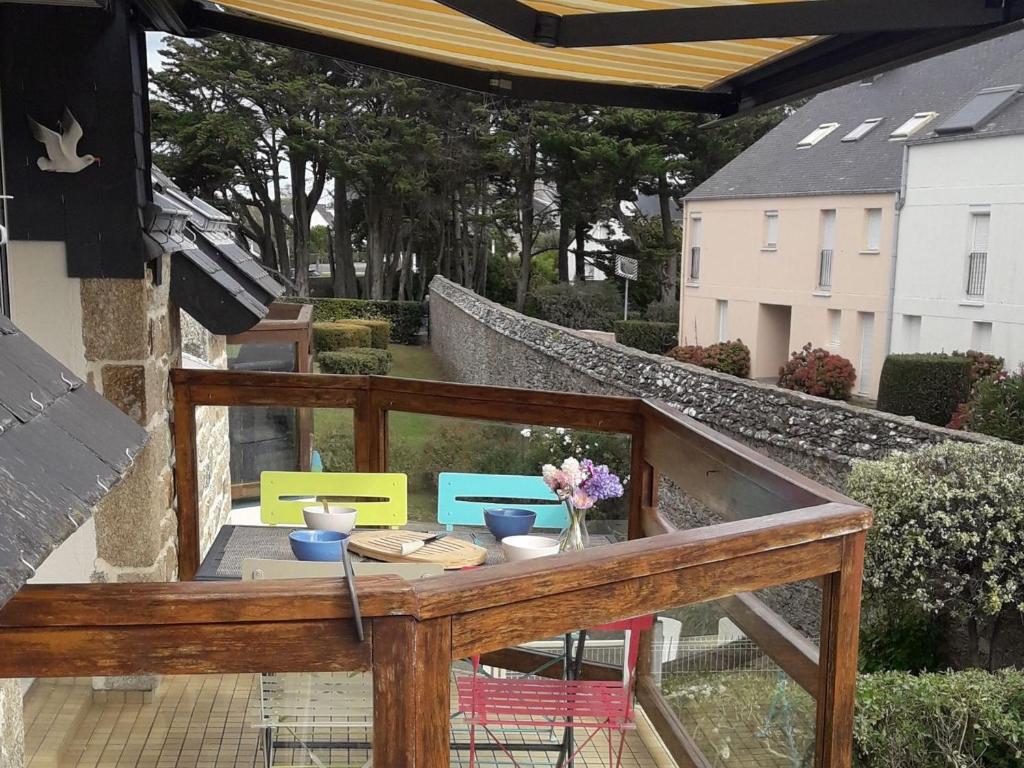 - un balcon avec une table et des fleurs dans l'établissement Duplex calme & lumineux près plage, 4 pers, parking privé - FR-1-775-13, à Sarzeau