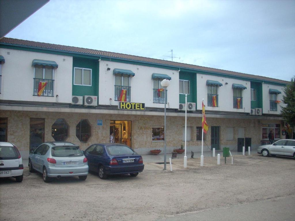 維拉雷斯迪拉雷納的住宿－卡斯蒂利亞科羅納酒店，门前有车辆停放的酒店