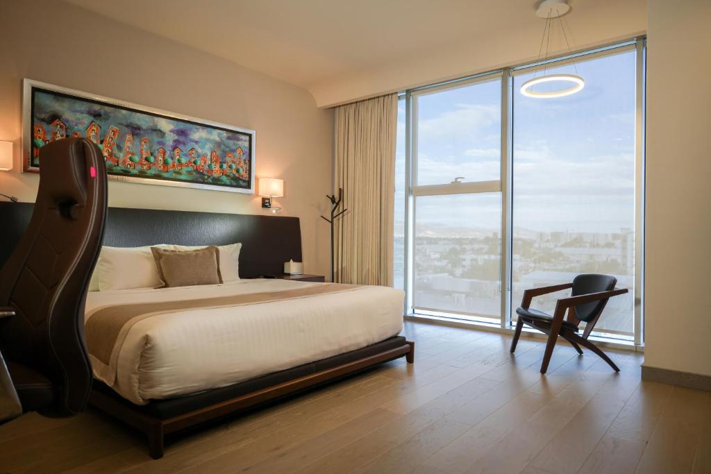 a bedroom with a large bed and a large window at Metria Hotel in León