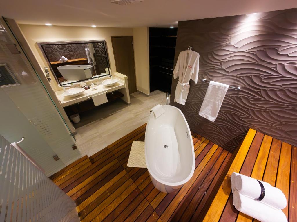 a bathroom with a bath tub and a sink at Metria Hotel in León