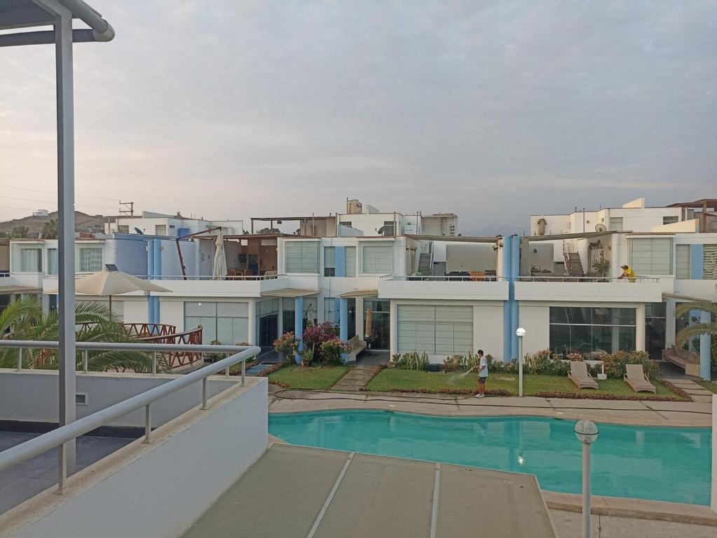 un grand immeuble avec une piscine en face de celui-ci dans l'établissement ESCAPA DE LA RUTINA Y DISFRUTA Asia - Chocaya, à Asia